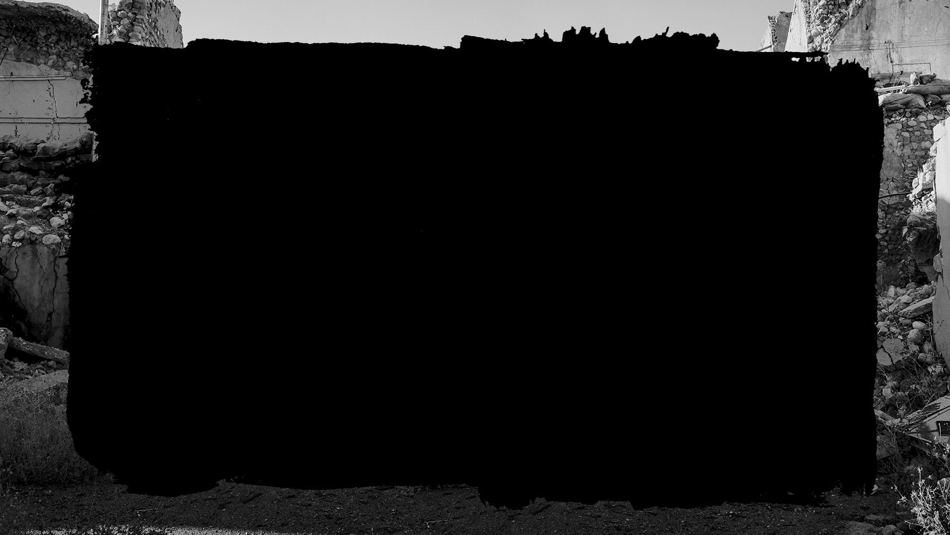 Tarja negra sobre fotografía en blanco y negro de un lugar aparentemente destruído por bombas.